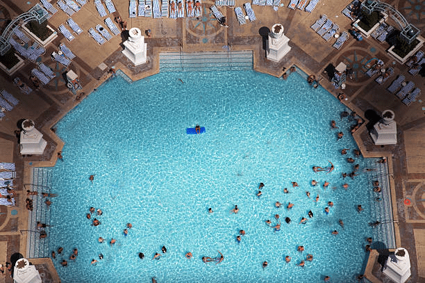 A swimming pool with people in it Description automatically generated