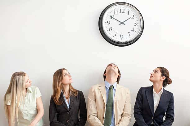 A group of people looking up at a clock Description automatically generated